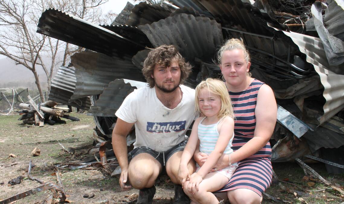 TRAGEDY: Toby Rixon-Gosch, Nicole Bailey and their five-year-old daughter Layla Rixon-Gosch show the remains of their house, which has been pushed into a pile in their yard. Pictures: Albert McKnight 