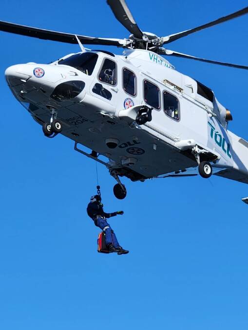 Toll rescue helicopter with paramedic being dropped into position. Picture supplied. 