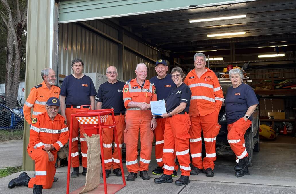 SES Eden unit members accept new sandbag machine from Nev Cowgill. Left to right - Brian Dixon, Bob Kulibab, Mark Lawrence, Wayne Elliott, Nev Cowgill, Peter Bickford, Patricia Daly, Robert Benkhauser and Pam Cocks. Picture supplied. 