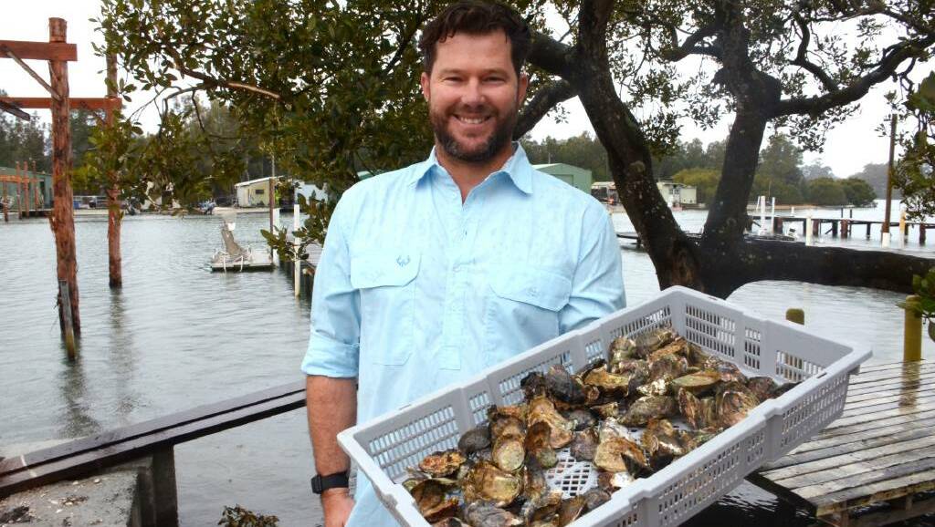 Oceanfarmr CEO Ewan McAsh holds a basket of Sydney rock oysters at his family farm on the Clyde River, Batemans Bay. 