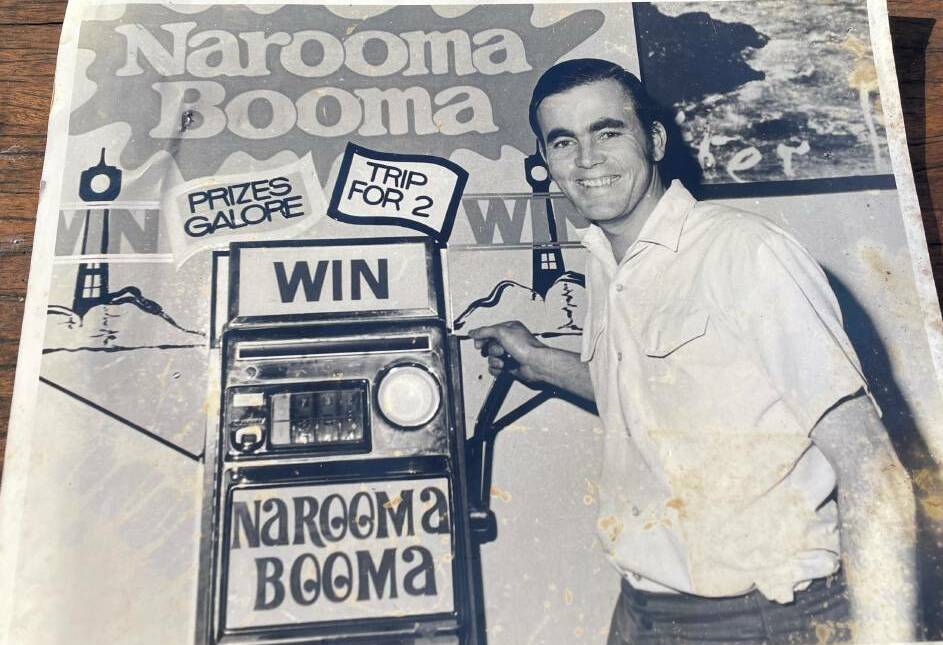 A photograph of a younger Bill Dudley running the Narooma Booma raffle to fund the running of the Visitor Information Centre. Picture supplied