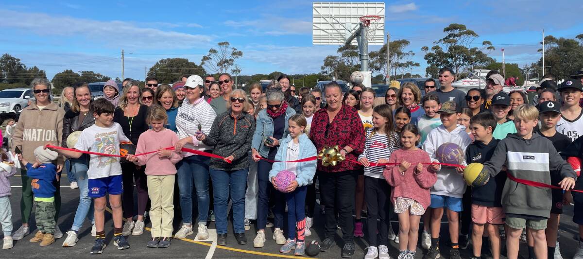 There were smiles and cheers all round as Wendy Douch cut the ribbon to formally open the new netball/basketball courts on Sunday, July 23. Picture by Marion Williams