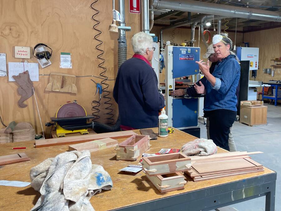 Sue Dickson and Jen Houghton in the Narooma Community Men's Shed workshop. They have progressed from making wedge-shaped doorstops and toaster tongs to the quite complicated boxes on the work bench. Picture by Marion Williams