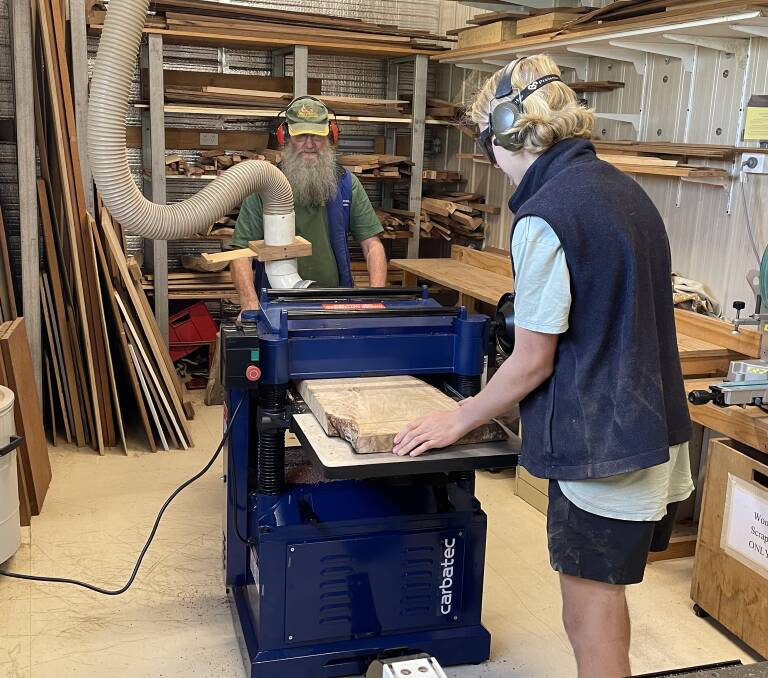 Aspiring carpenter Jamie Parker-Barnes testing out the new thicknesser with the help of Bega Woodies Vice President Don Firth. Picture by Sam Armes. 