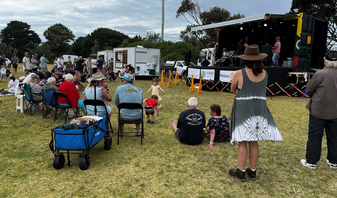 Market-goers taking in some live music at the New Years Eve Rotary market in Merimbula. Picture supplied. 