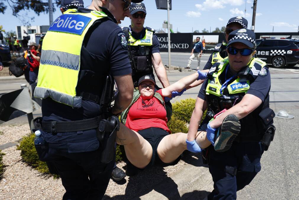 Pro-palestine protesters and police at the perimeter of the Flemington Racecourse on Melbourne Cup Day in Melbourne, Tuesday, November 7, 2023. (AAP Image/Con Chronis)