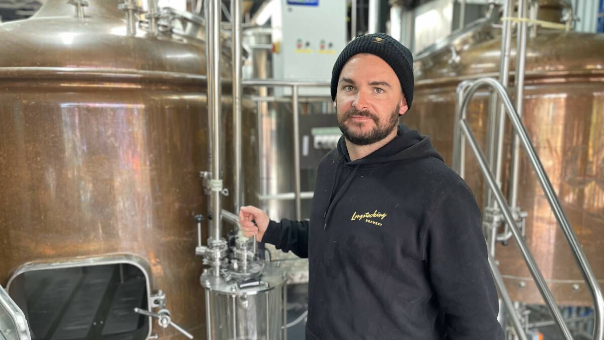 Head Brewer Matt alongside two Mash Tuns; insulated chambers where grains and water mix to create a wort. Picture by James Parker.
