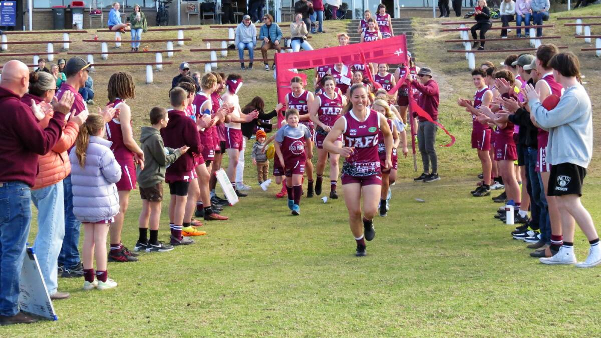 Cymmon Parker leads her team on to the ground. Picture by Shirley Rixon