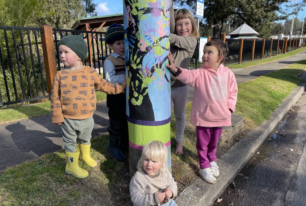 Haydee, Ellis, Frank, Forest and Ocean show off their 'hand-painted' pole, one of the first to have been painted in the Cobargo main street project. Photo: Ben Smyth