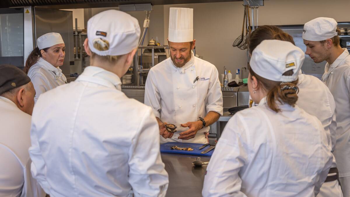 TAFE NSW Bega commercial cookery teacher Dave Arens shows TAFE NSW apprentices some of the finer points of preparing local seafood delicacies at a special industry support night. Photo by David Rogers Photography