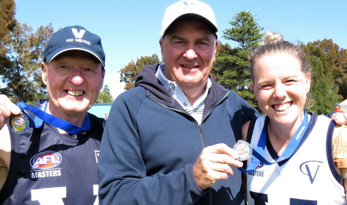 2022 AFL Masters National Champions Neil Rainbow and Naomi Shoebridge with the legendary Ted Whitten Junior. Picture by Shirley Rixon